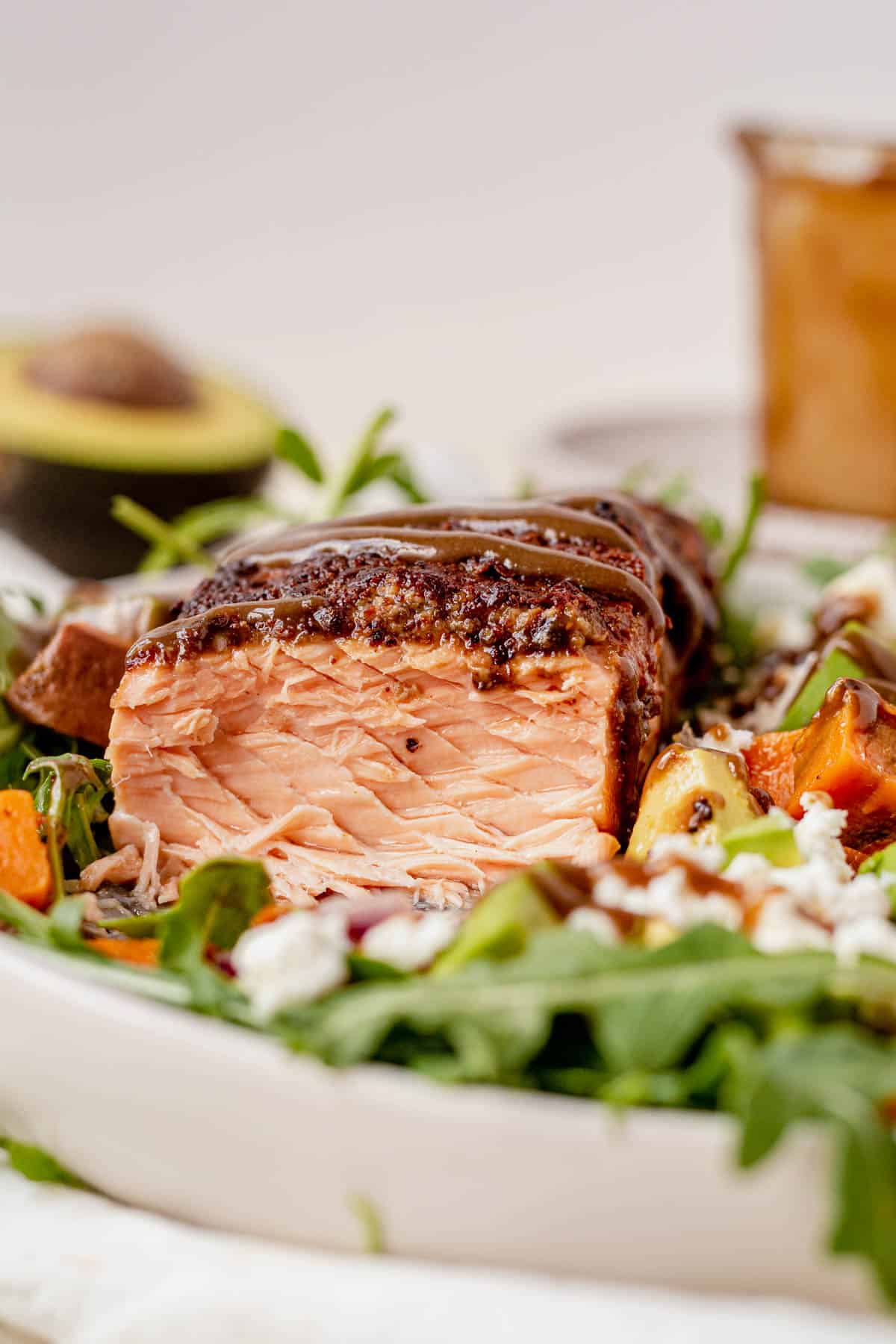 the inside of a piece of flaky salmon on top of a bed of arugula