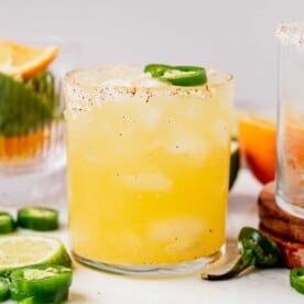 a skinny spicy margarita in a cup with salt and jalapenos