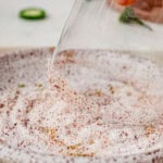 dipping a margarita glass in salt and Tajin