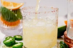 pouring a spicy skinny margarita into a glass of ice