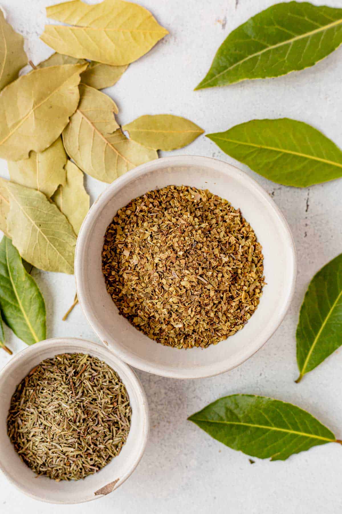 bay leaf, oregano, and dried thyme in bowls