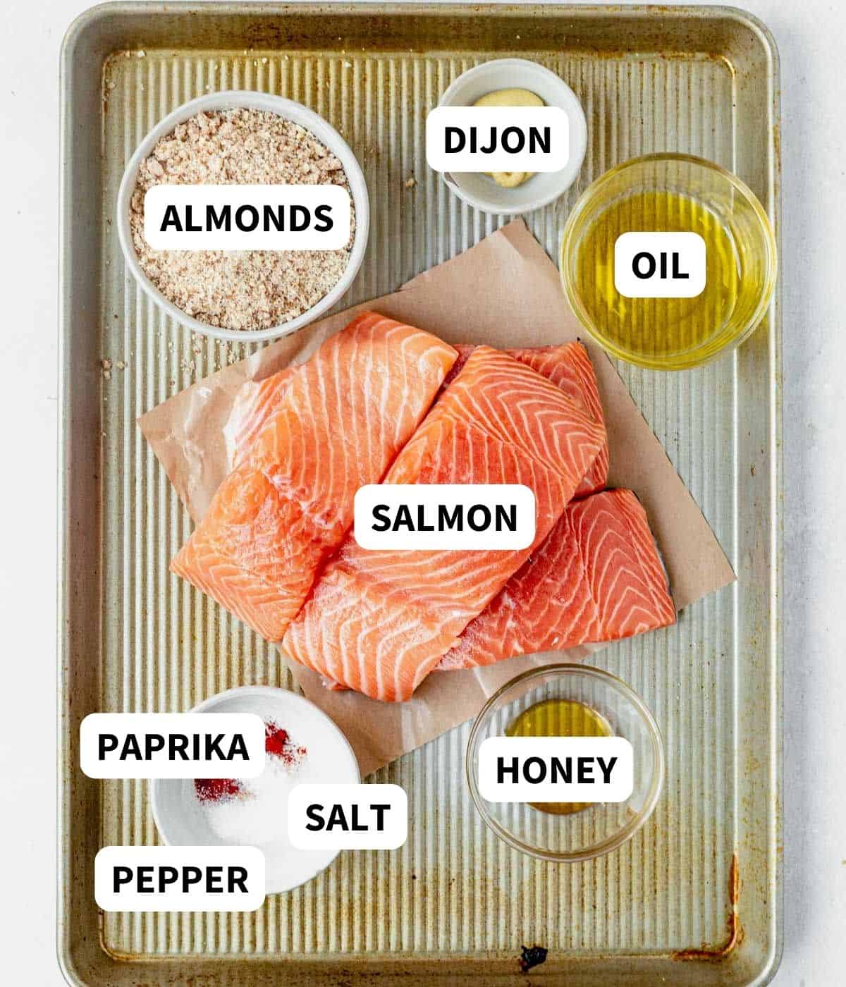salmon, almond, dijon, honey, and spices on a baking sheet