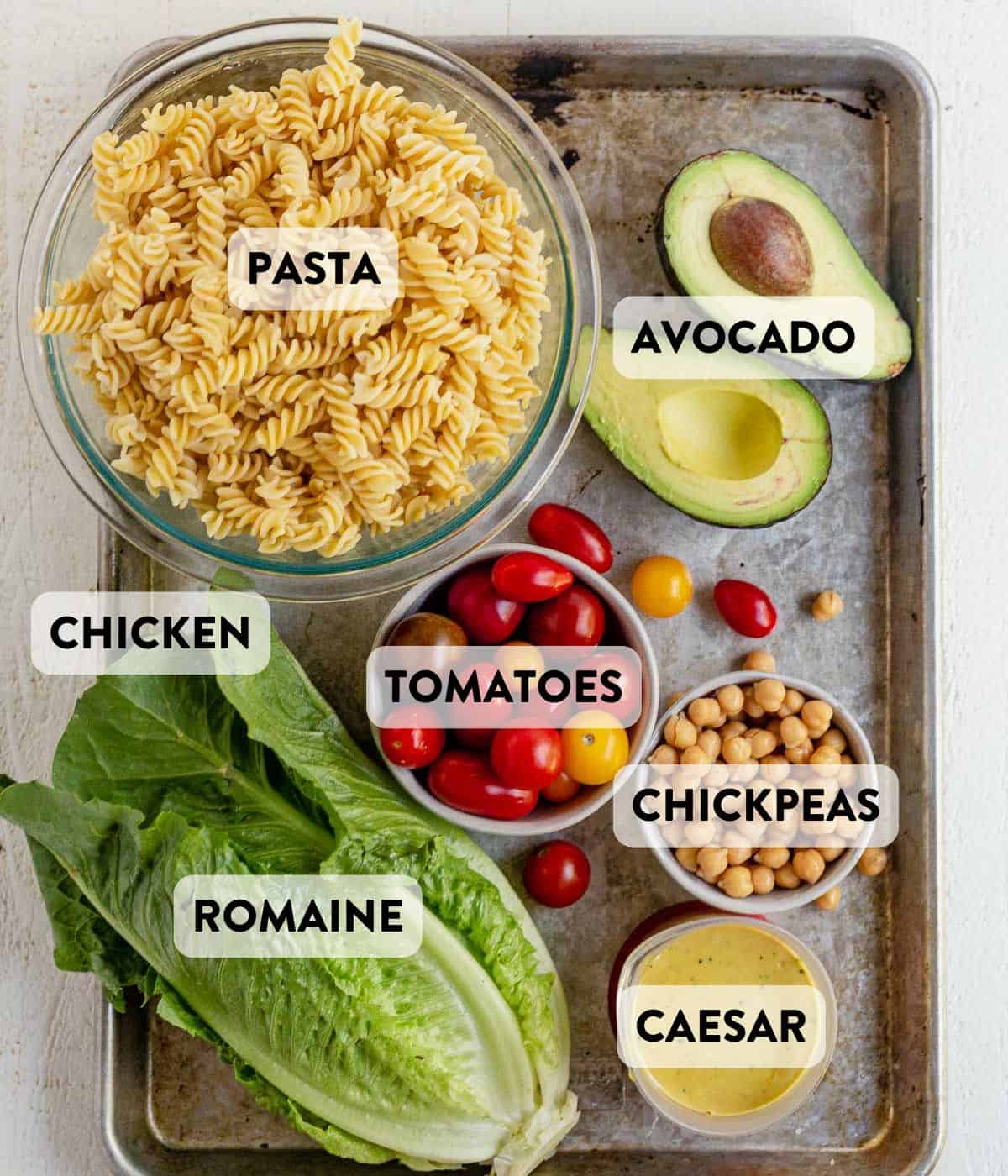 chicken caesar pasta salad ingredients on a counter.