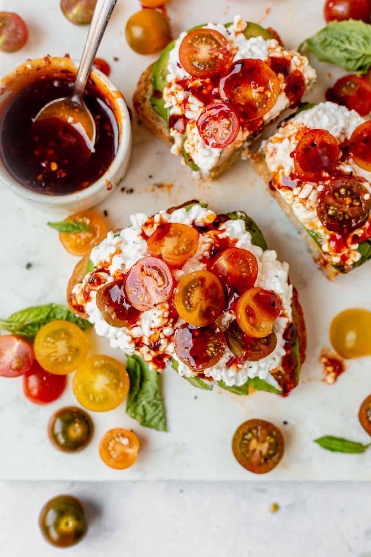 two pieces of cottage cheese toast with tomatoes and honey