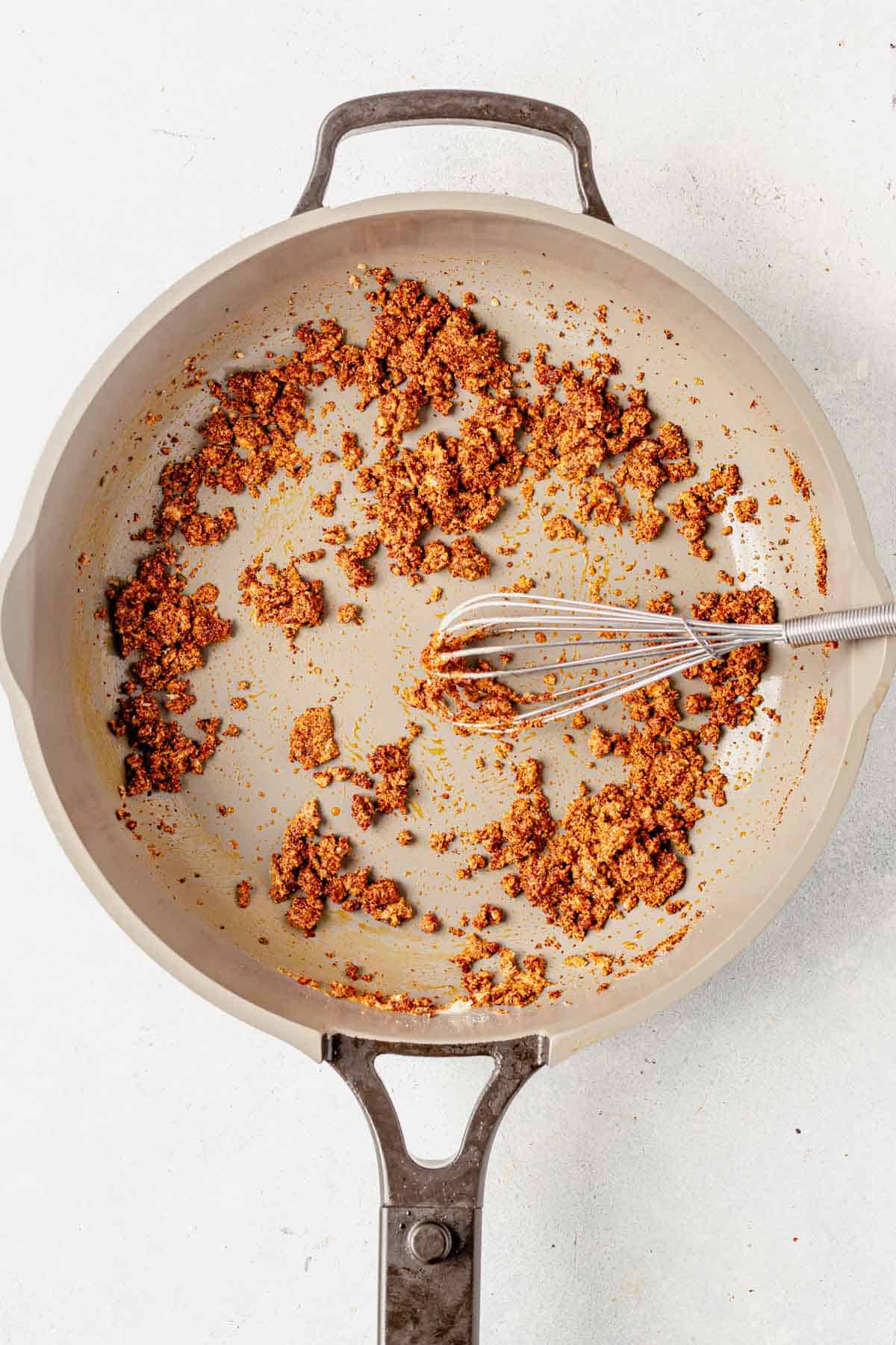 gluten-free flour and the spices for gluten-free enchilada sauce whisked together in a pan on the stovetop.
