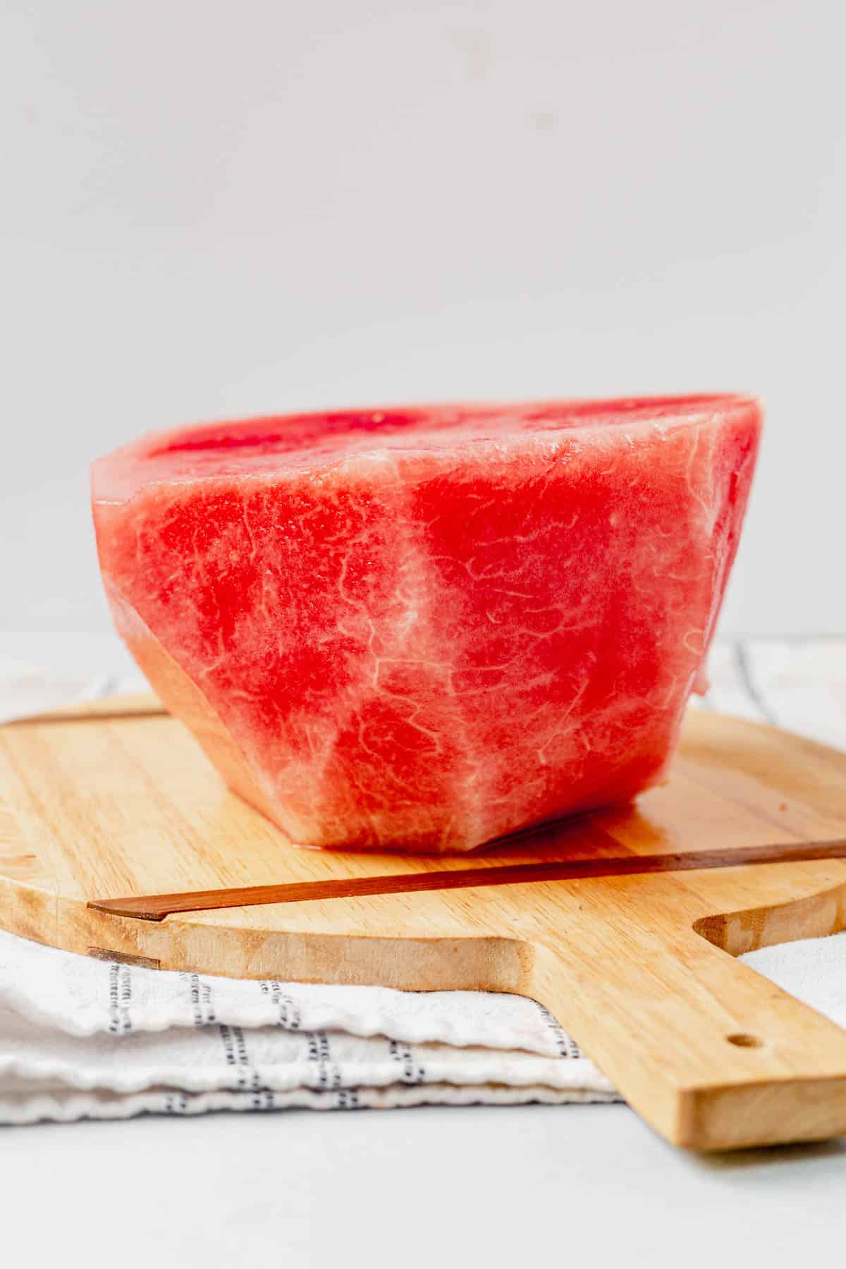 half a peeled watermelon on a cutting board