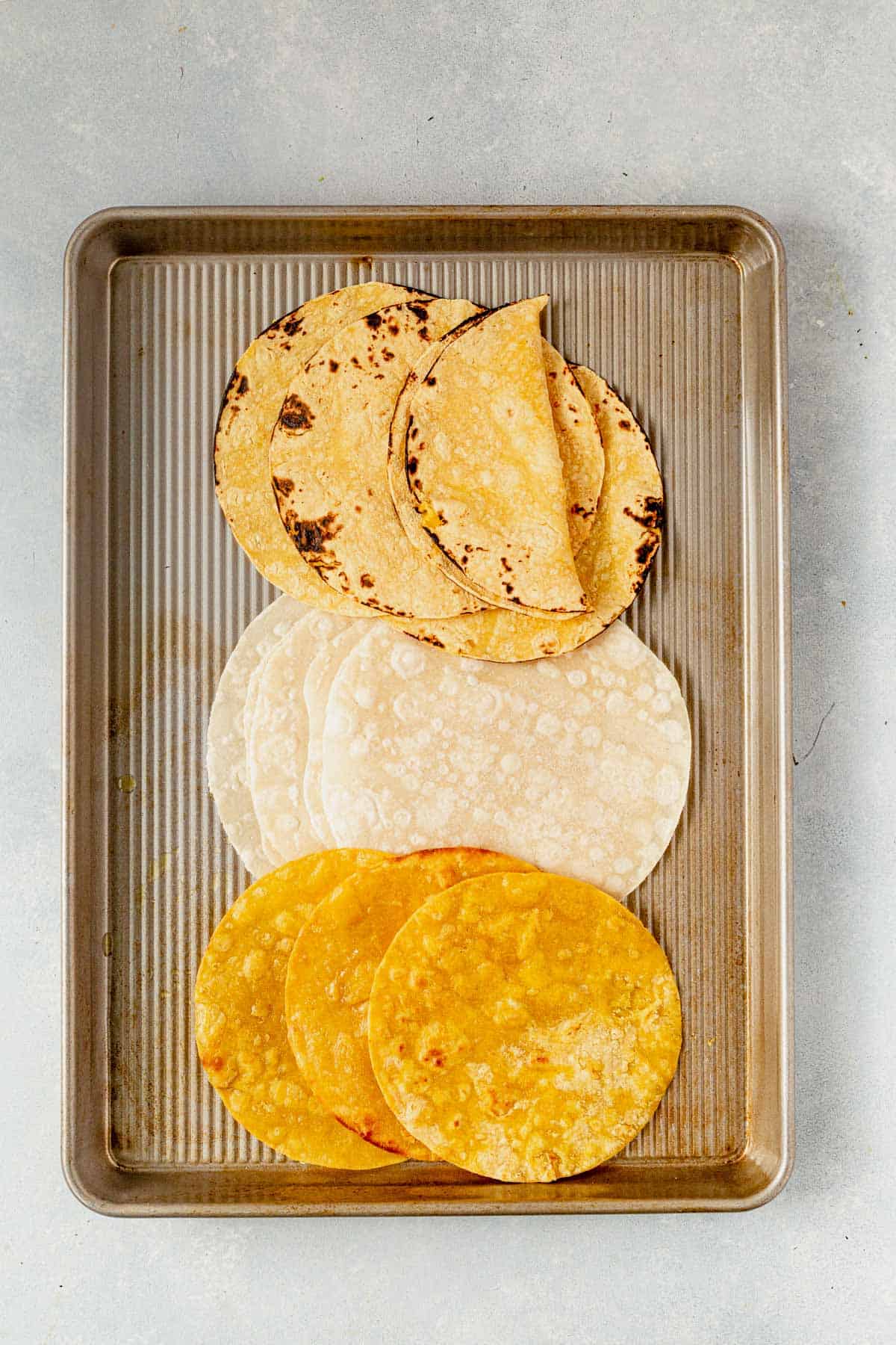 softened corn and flour tortillas on a tray