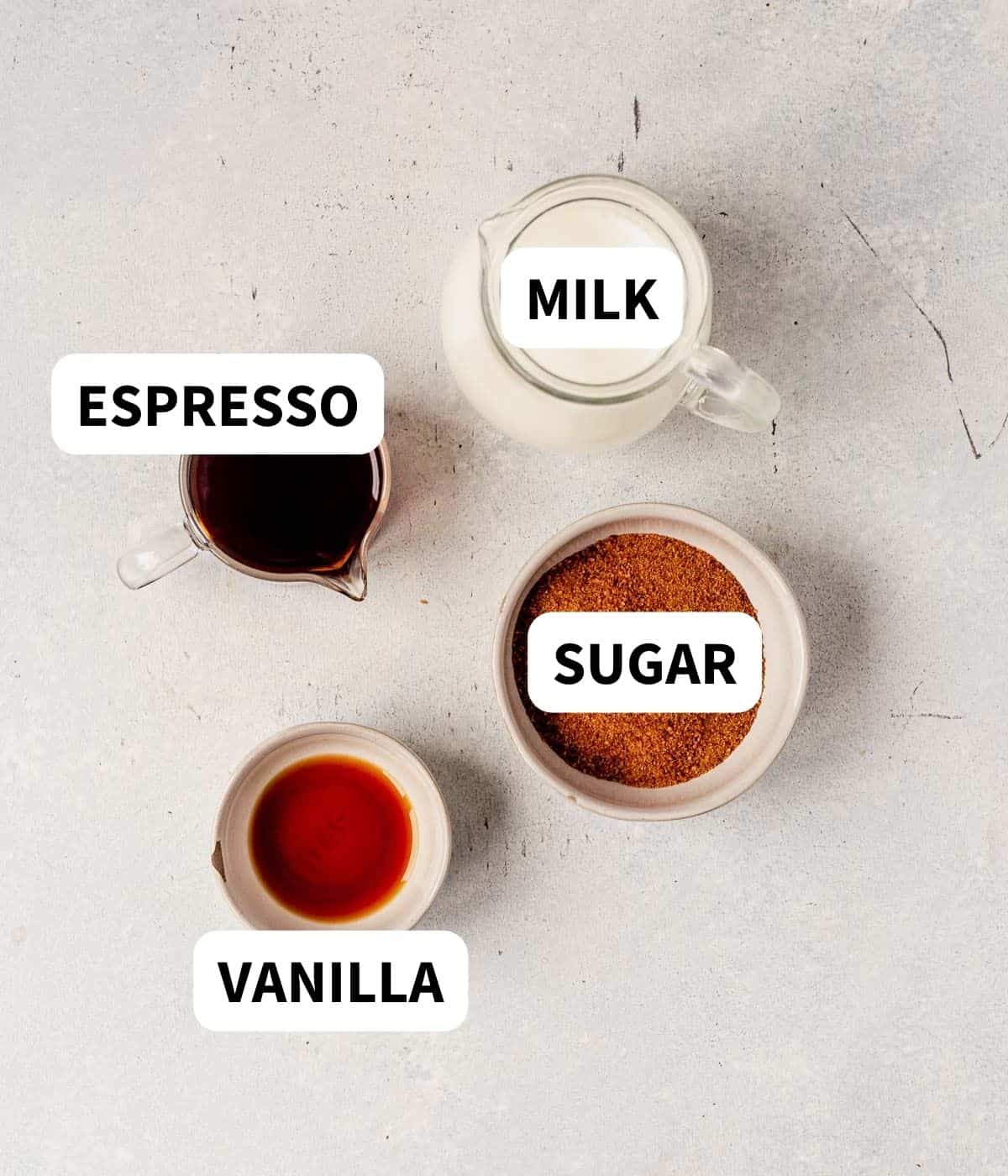 espresso, sugar, vanilla and milk on a countertop