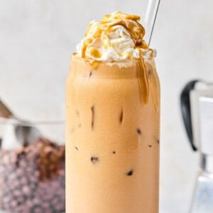 homemade iced caramel latte recipe topped with whipped cream and caramel sauce.