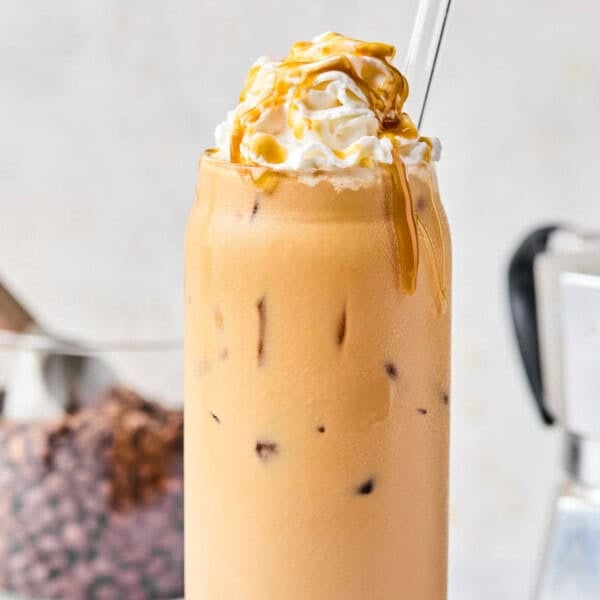 homemade iced caramel latte recipe topped with whipped cream and caramel sauce.