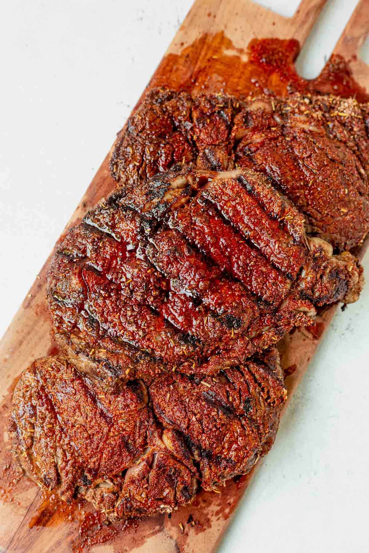 3 grilled steaks on a cutting board