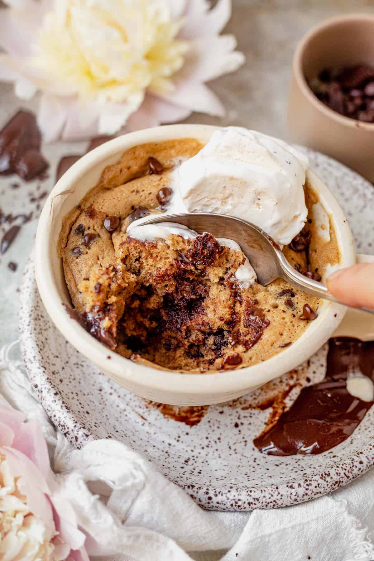 taking a bite out of a chocolate chip mug cake