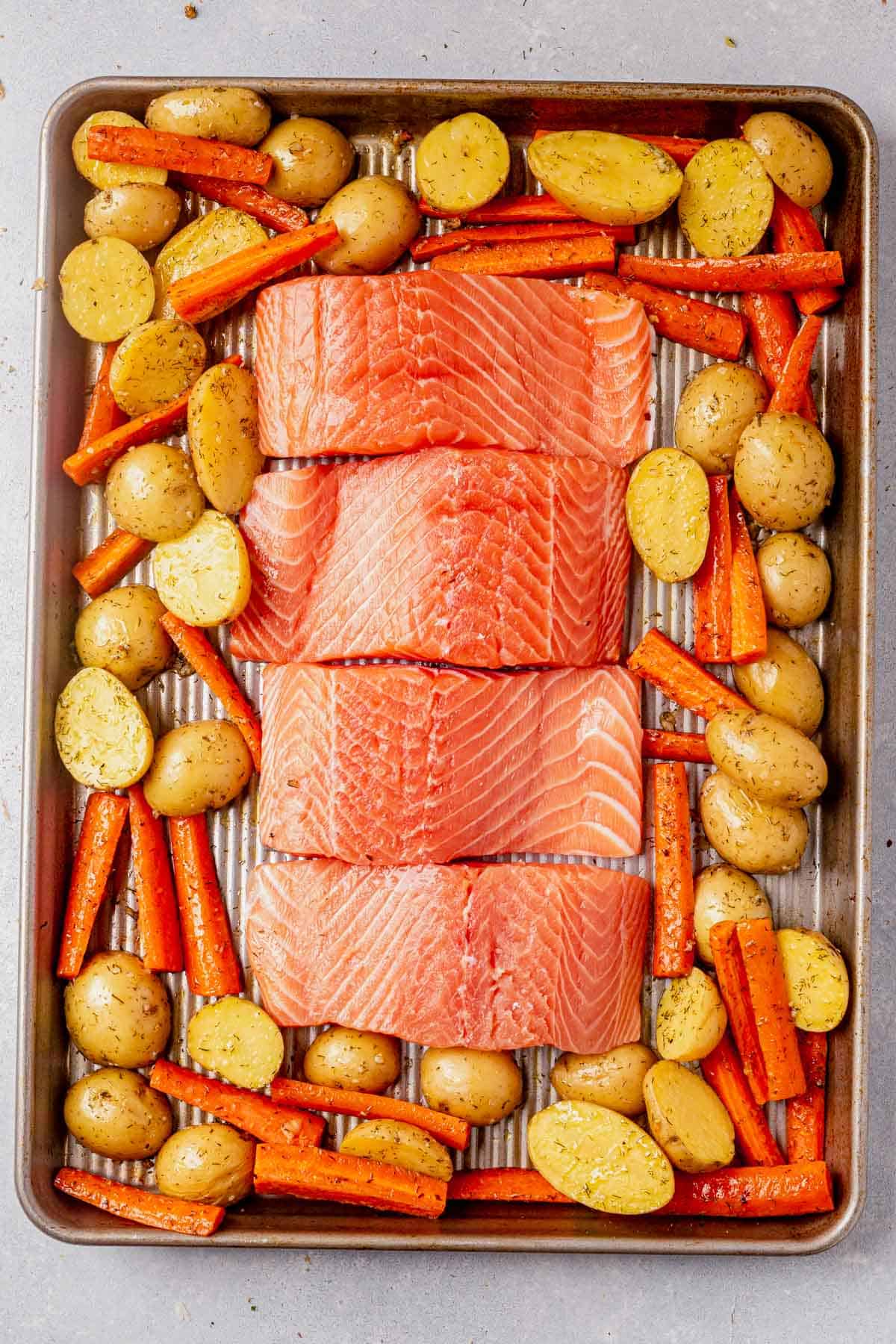 carrots, potatoes, and salmon on a sheet pan