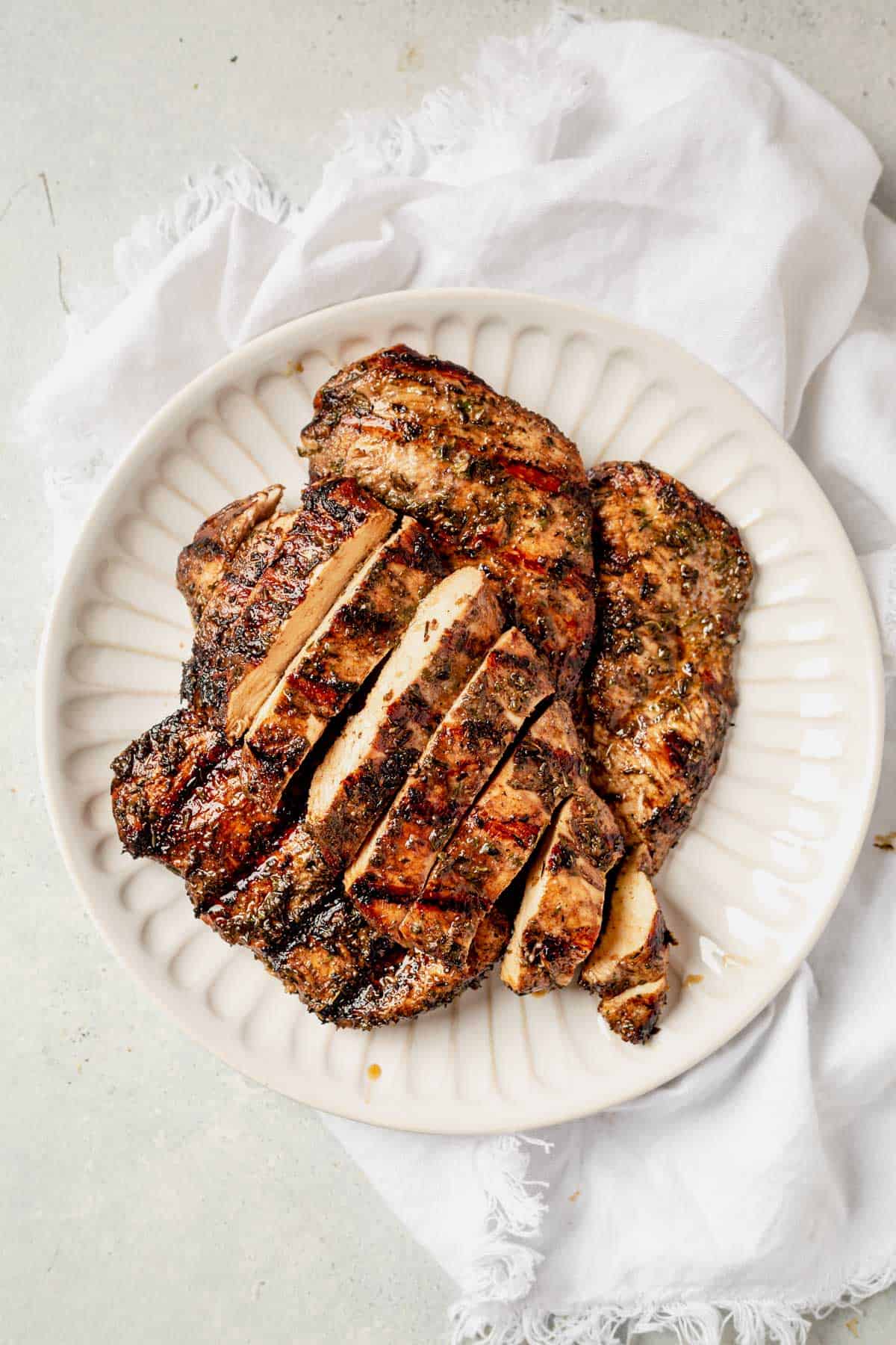 sliced and grilled chicken breast on a serving plate