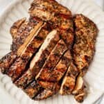 sliced and grilled chicken breast on a serving tray