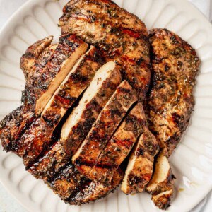 sliced and grilled chicken breast on a serving tray