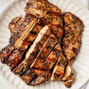 sliced and grilled chicken breast on a serving tray