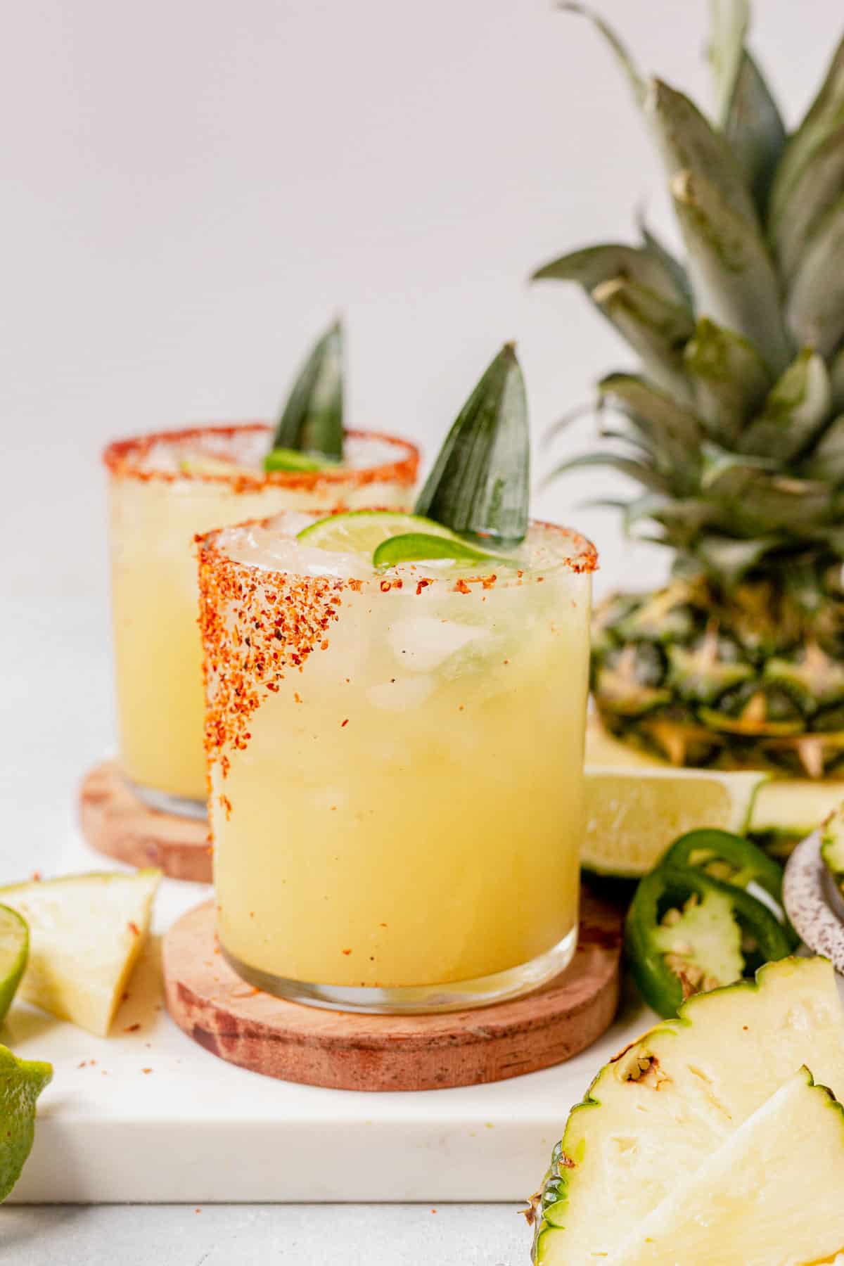 two pineapple jalapeno margaritas on a counter