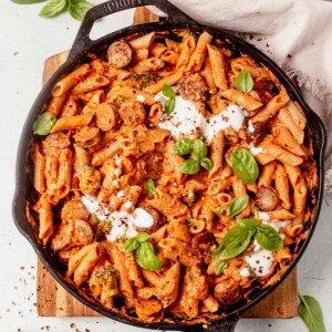 chicken sausage pasta in a skillet with fresh basil