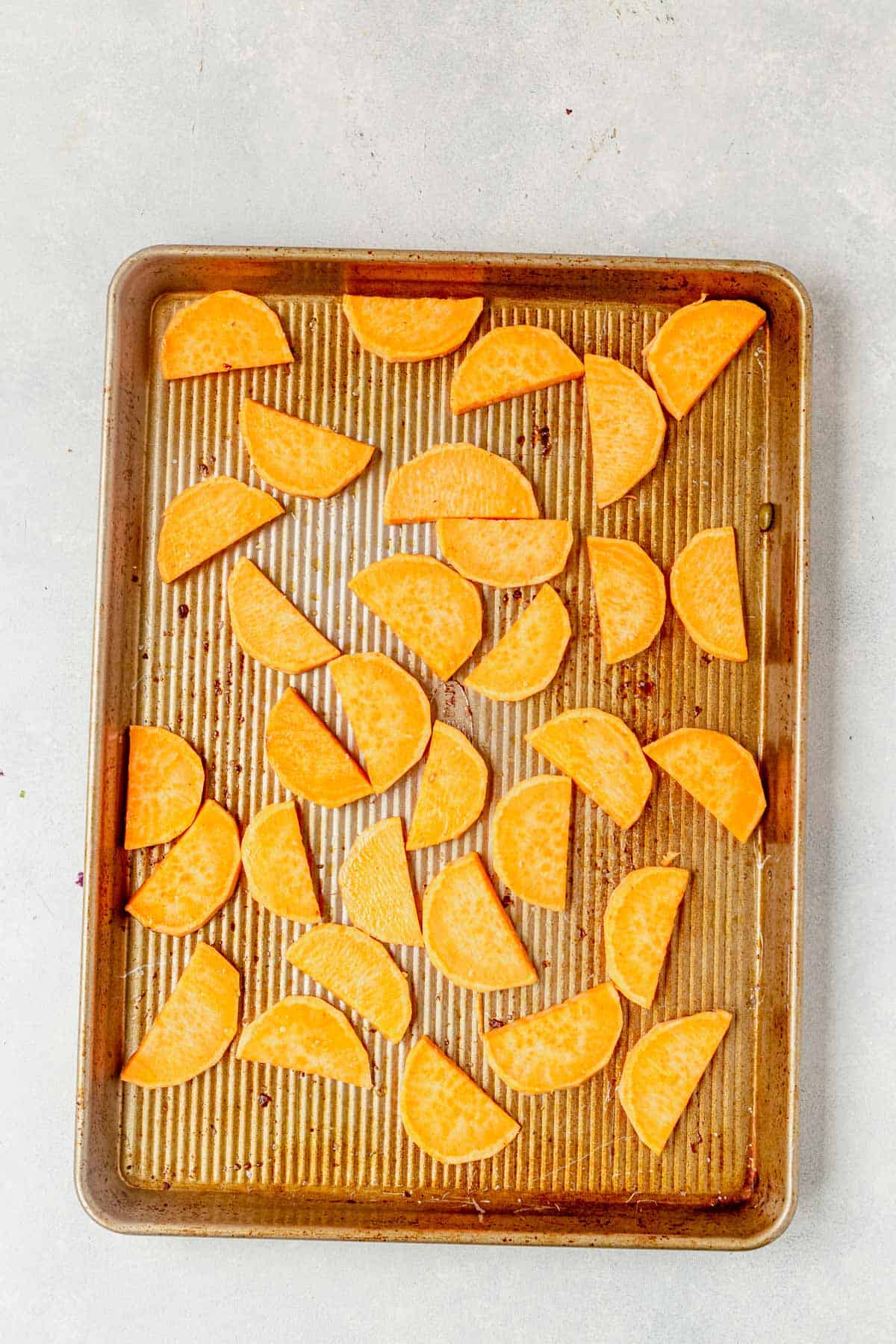 sliced sweet potatoes on a sheet pan