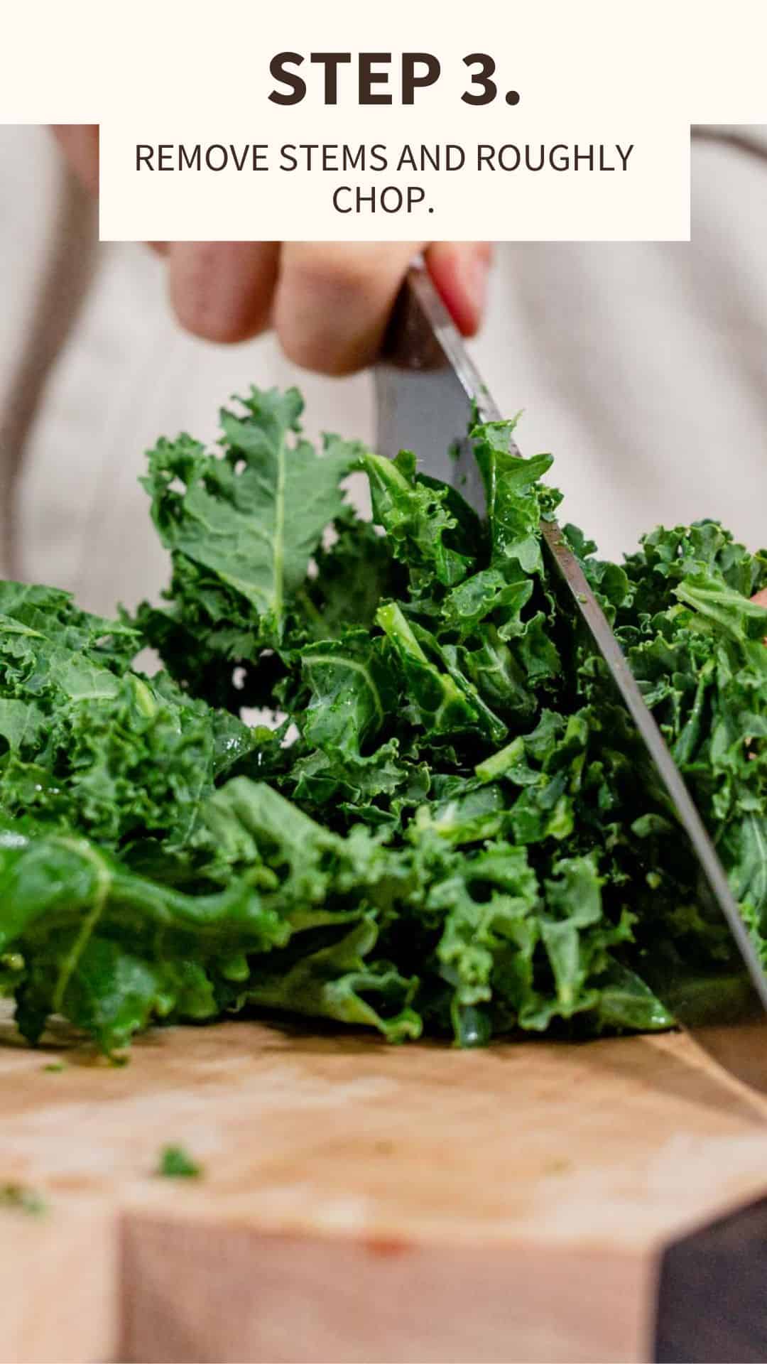 knife chopping kale on a wooden cutting board