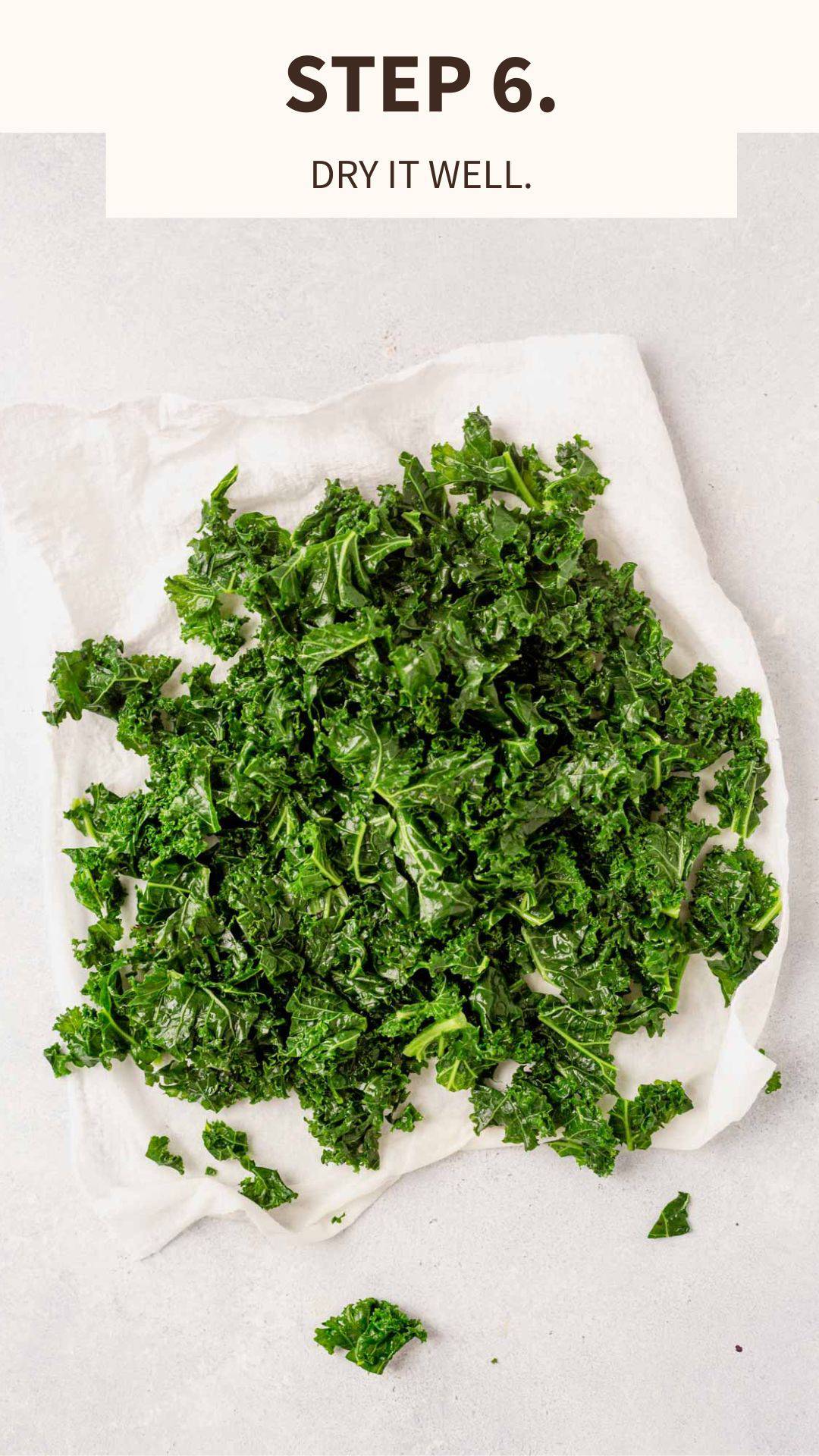 kale being patted dry on a paper towel