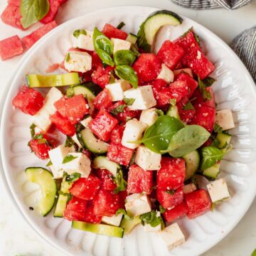 a plate of watermelon basil salad with feta and cucumbers