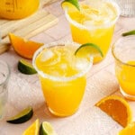 mango margarita recipe on the rocks with a salt rim and a lime wedge.
