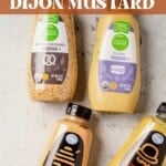 a bottle of dijon mustard and bottles of three other alternatives for it laying out on a counter