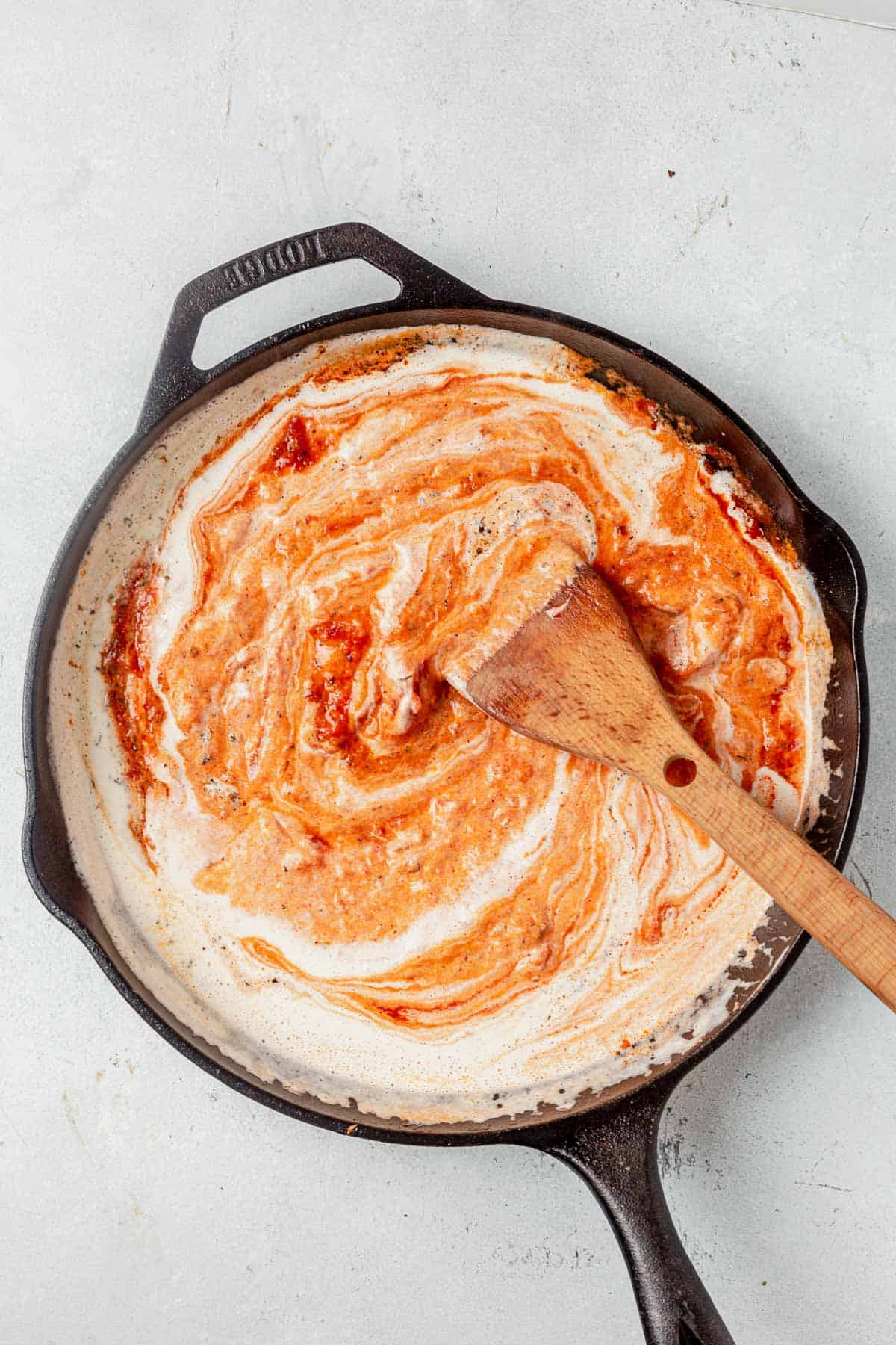 cashew cream and tomato sauce mixed in a pan