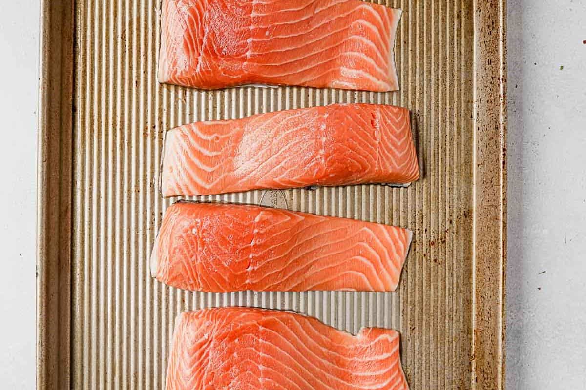salmon fillets on a baking sheet