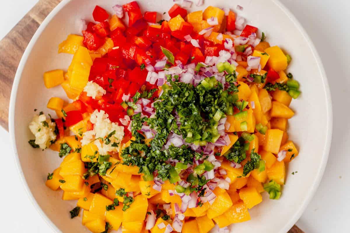 diced peaches, peppers, mango, and cilantro in a bowl