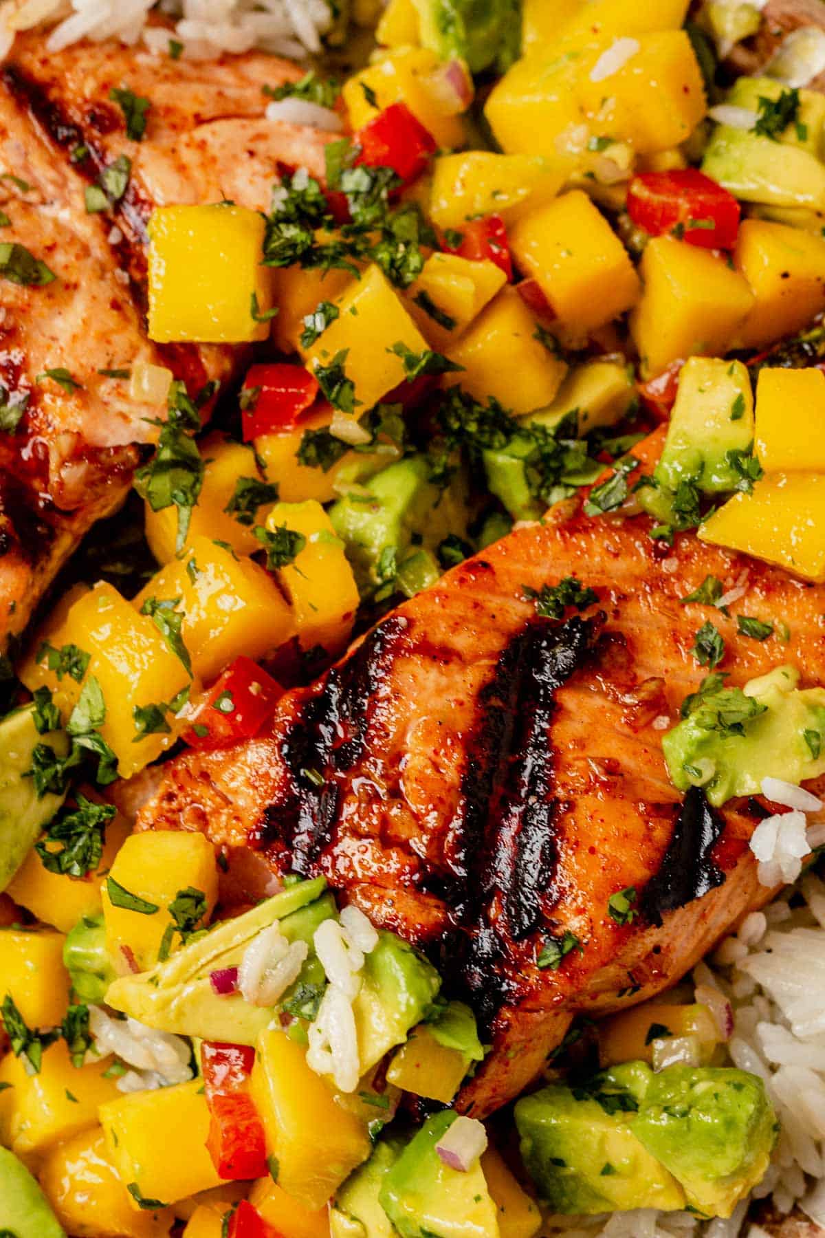 grilled salmon covered in mango avocado salsa