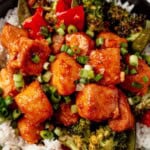 air fryer salmon bites on a bed of rice with broccoli and scallions.