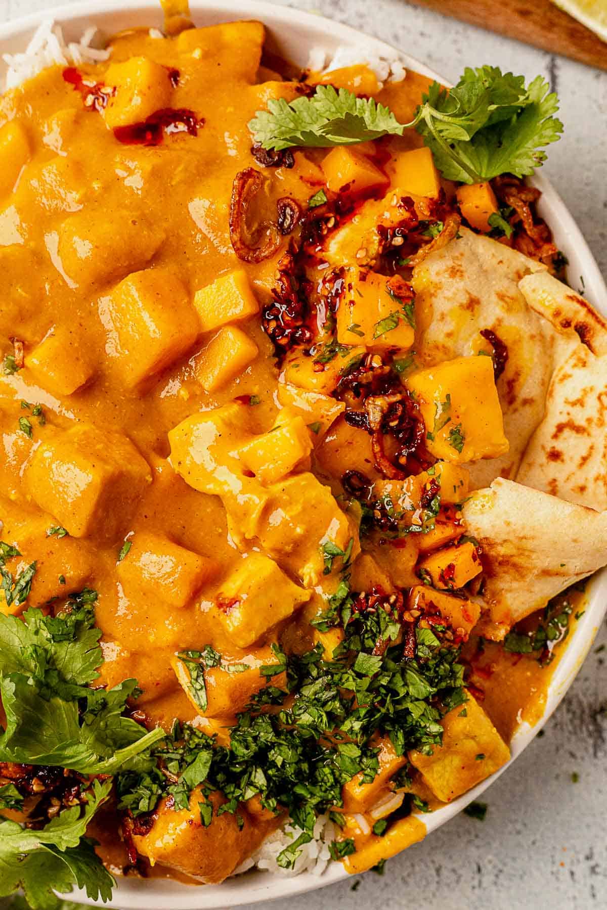 warm naan in a bowl with mango curry chicken