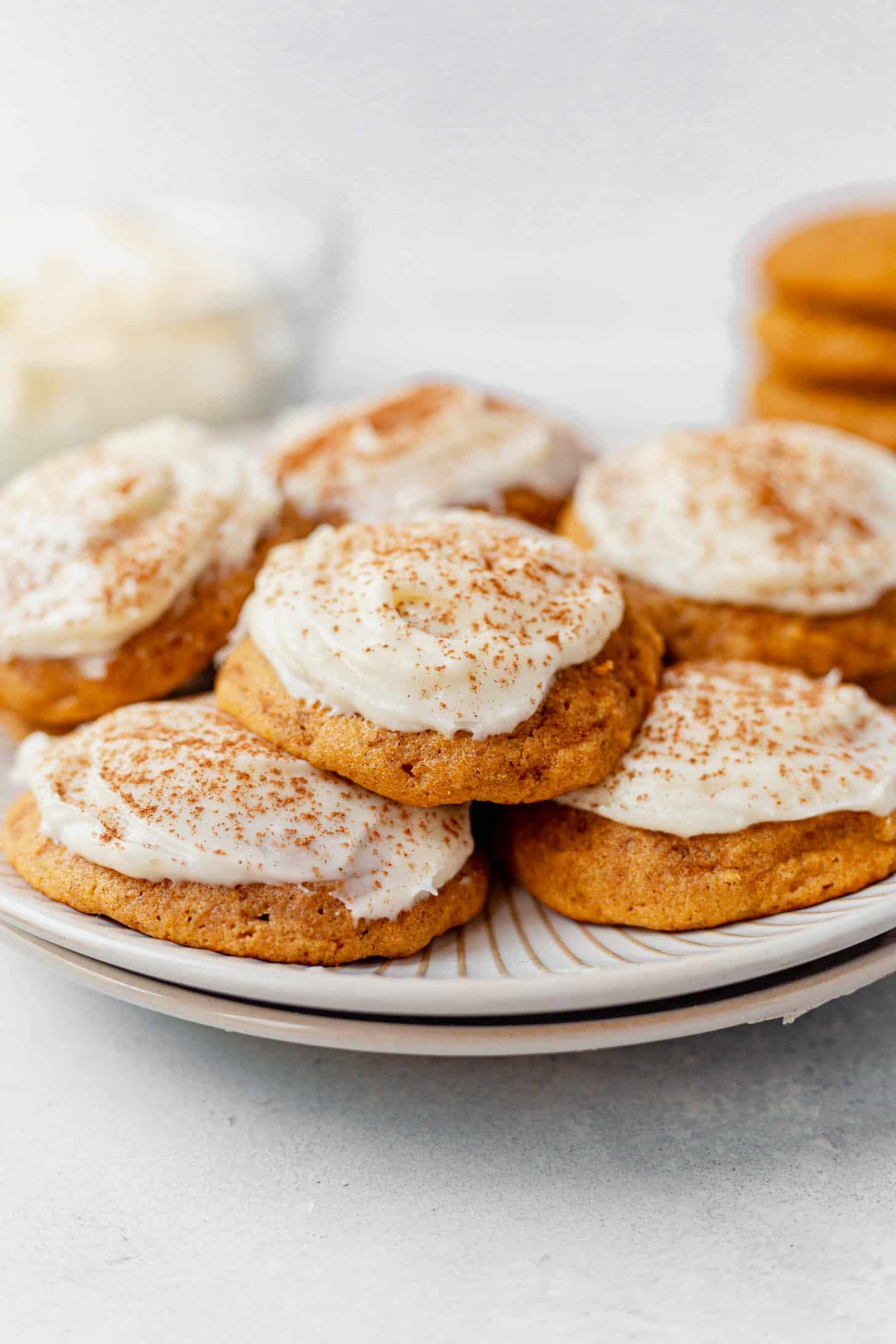 soft pumpkin cookies with cream cheese frosting on a white plate
