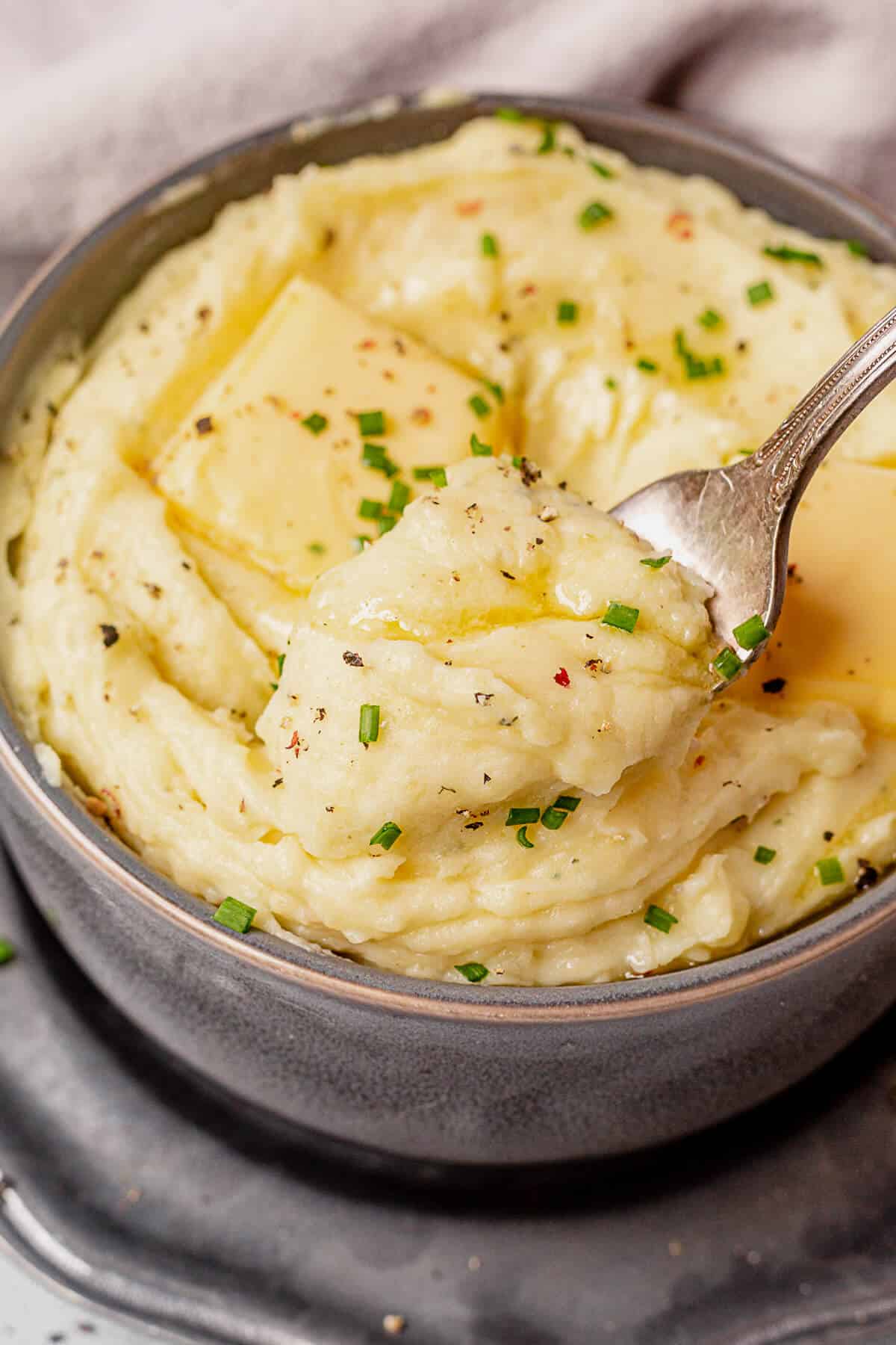 a bowl of boursin mashed potatoes with a forkful coming out