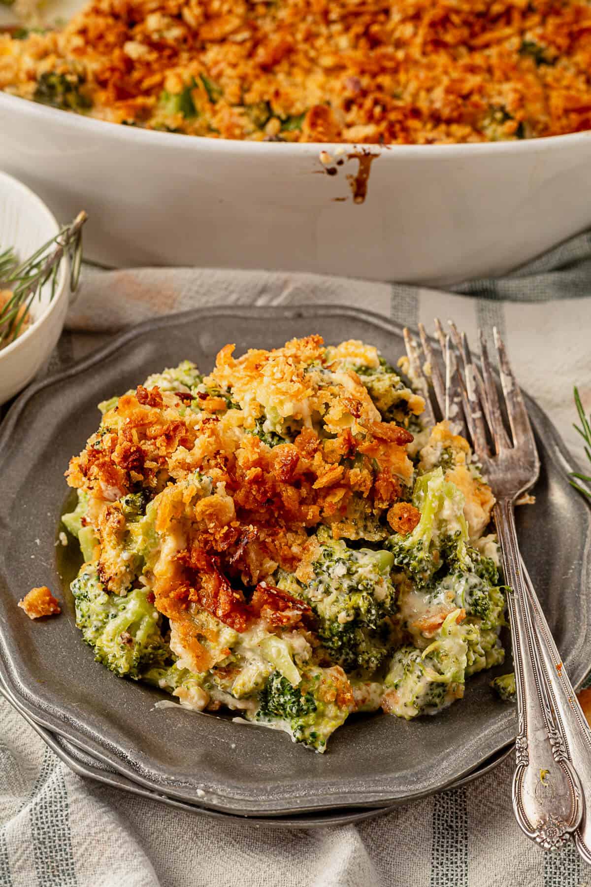 a large serving of broccoli casserole on a plate with ritz topping and two forks
