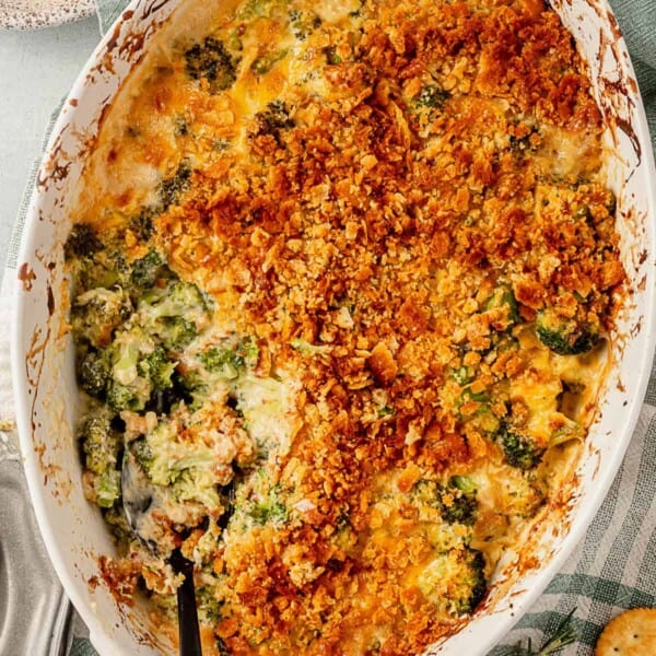 broccoli casserole with golden brown buttery ritz topping with a scoop taken out and a serving spoon resting in it