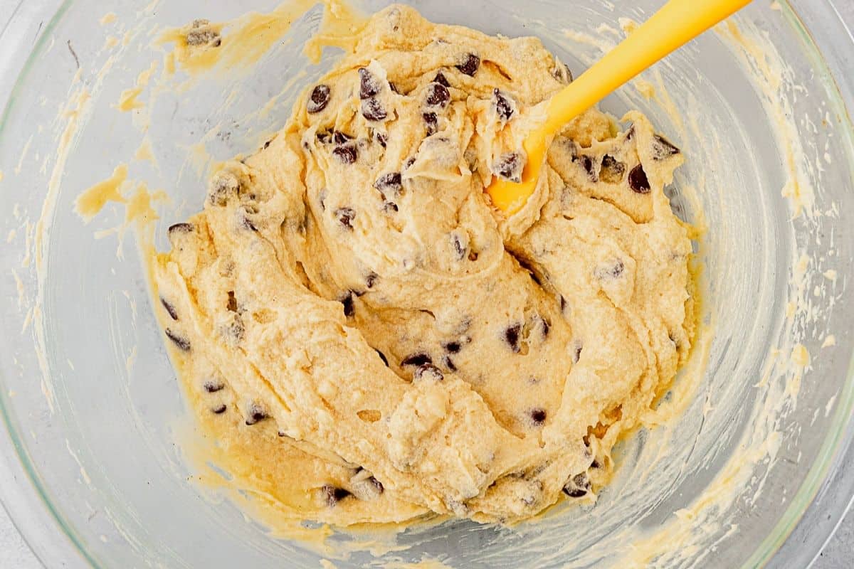 chocolate chip pie filling in a glass bowl with rubber spatula