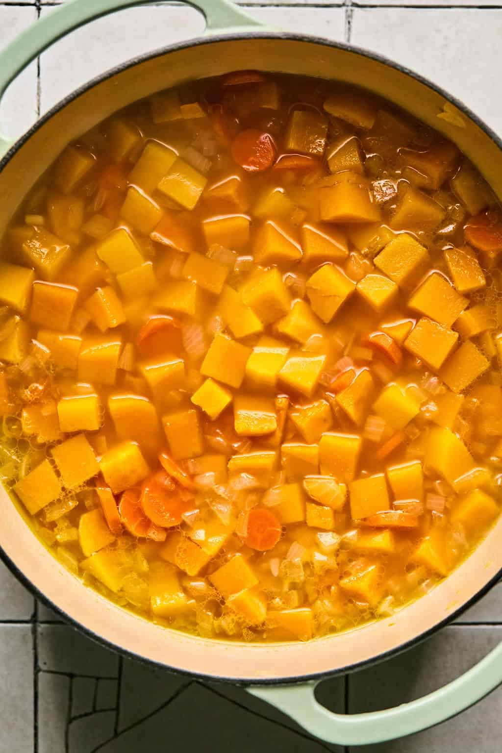 butternut squash and carrots simmering in a pot.