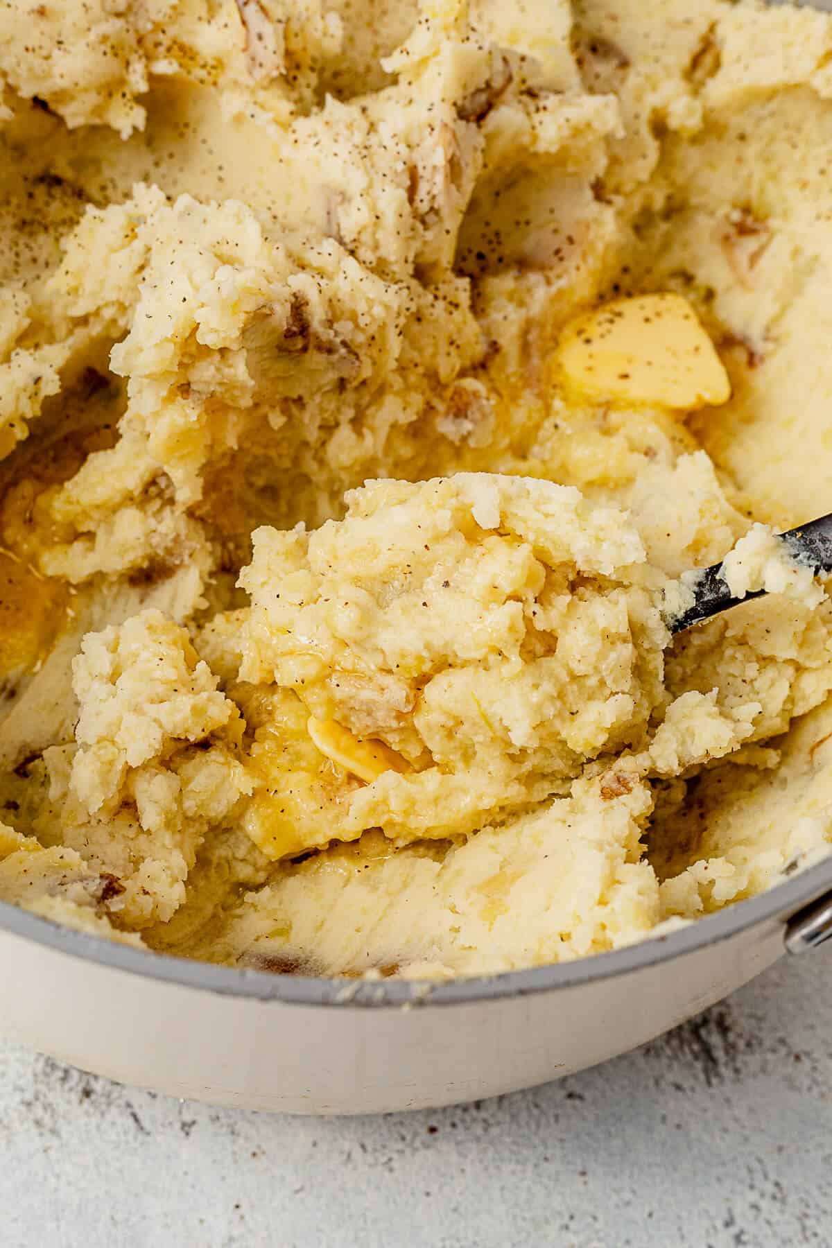 scooping mashed potatoes out of a pot