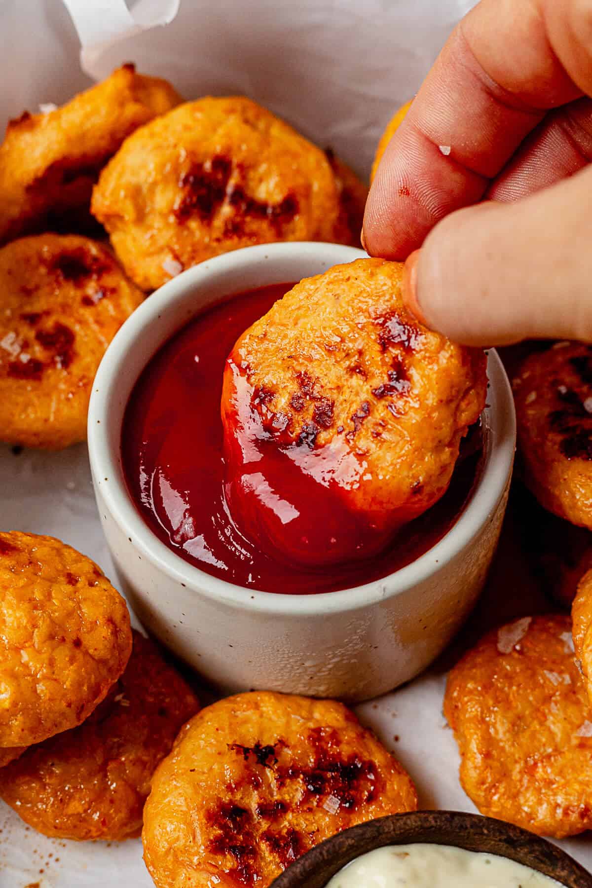 dipping a healthy chicken nugget into ketchup
