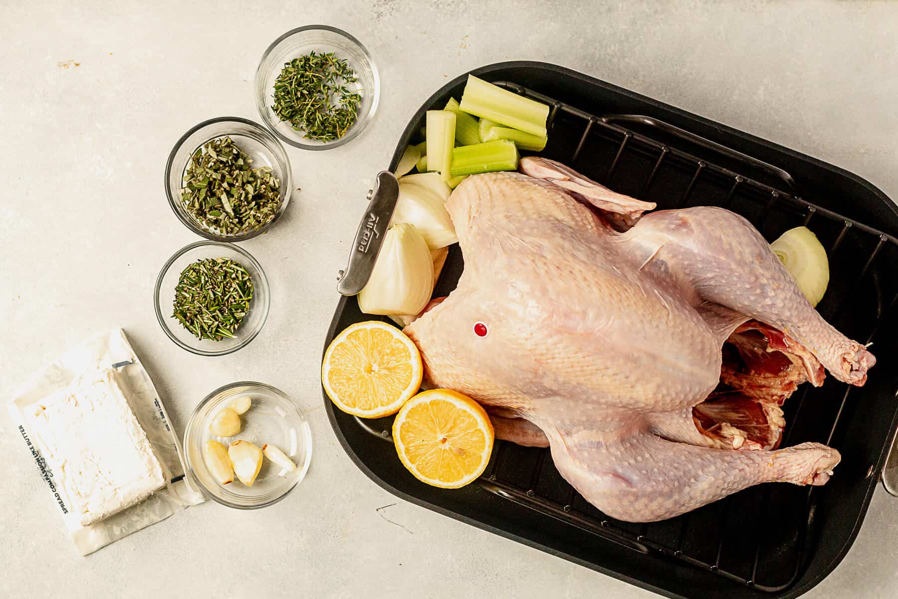 uncooked turkey breast with herbs, butter, and garlic