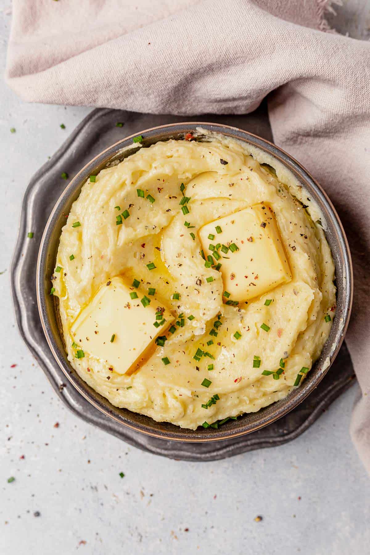 a bowl of creamy mashed potatoes with butter and herbs