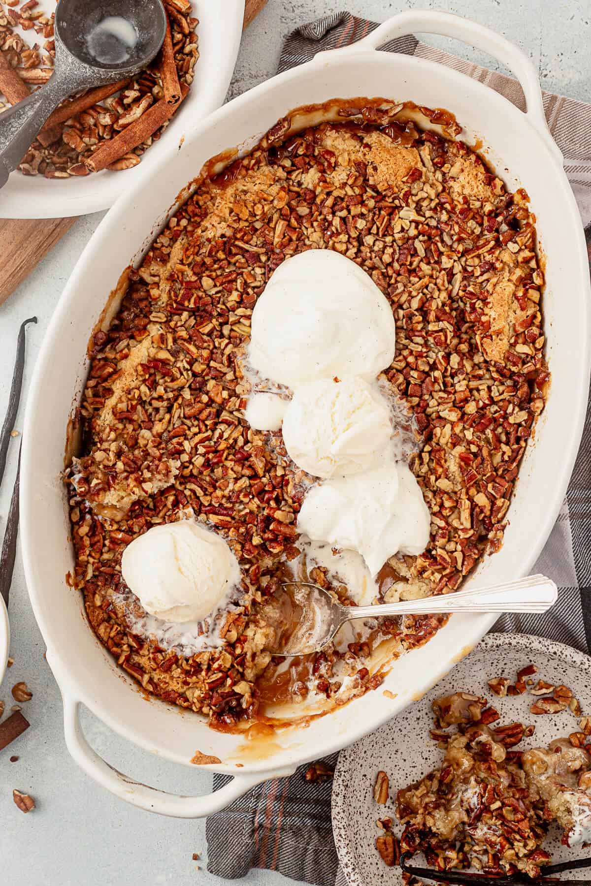 a scoop taken out of pecan pie cobbler in a 3 quart dish with ice cream