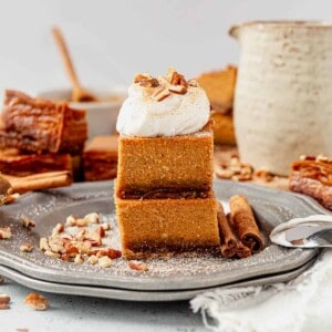 a stack of pumpkin pie bars with whipped cream