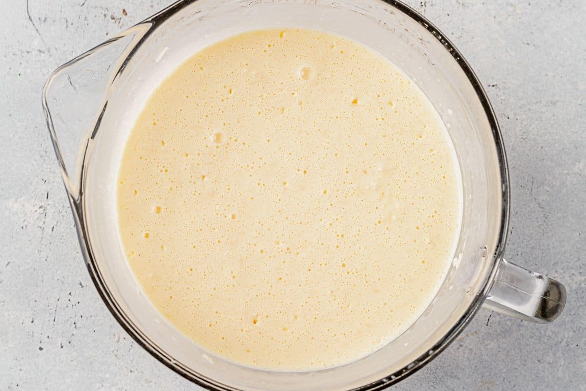 milk, cream, eggs, and water mixed together in a bowl for savory bread pudding