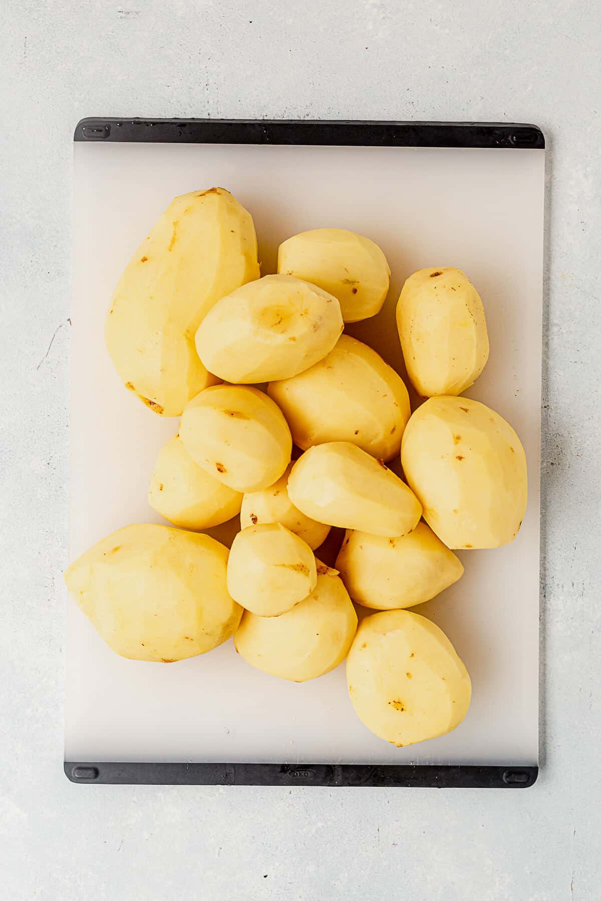 peeled yukon gold potatoes on a cutting board.