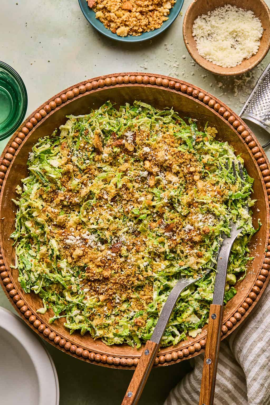 brussels sprout caesar salad in a salad bowl with tongs.